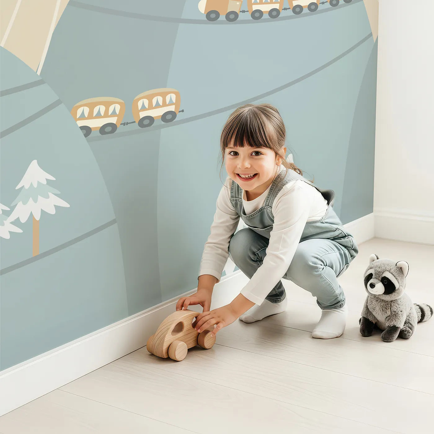 Child in front of Whimsy Tots Mountain Train Adventure Wall Mural with train, mountain, hill, house, hot air balloon, bridge, tree in design.