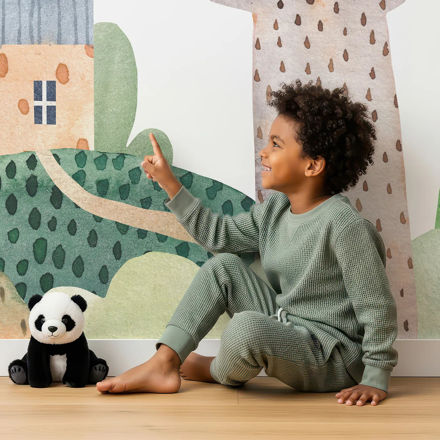 Child in front of Whimsy Tots Rainbow Hills Town Wall Mural with town, house, rainbow, watercolor, car, hill, colorful, city in design.