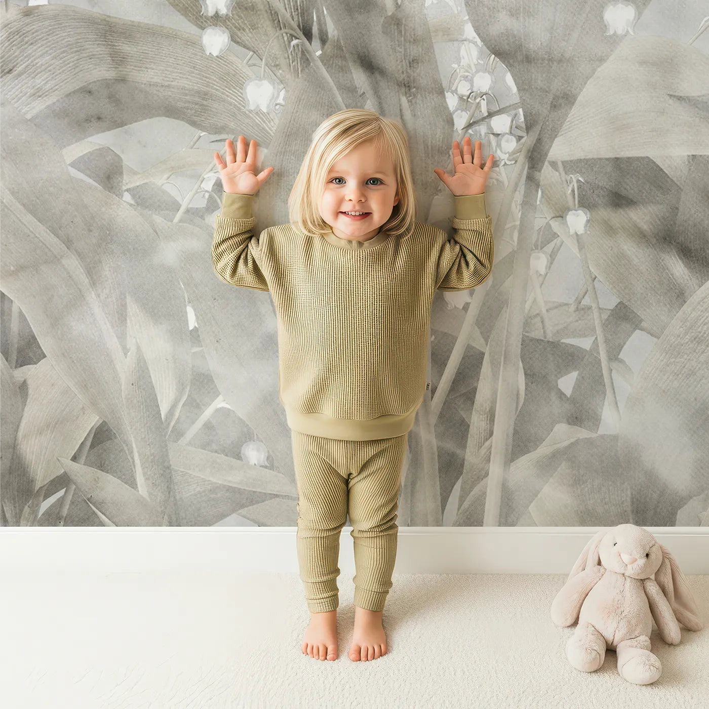 Child in front of Whimsy Tots Lily of the Valley Marble Wall Mural with flower, lily of the valley, marble, gray, beige, elegant, modern, floral in design.