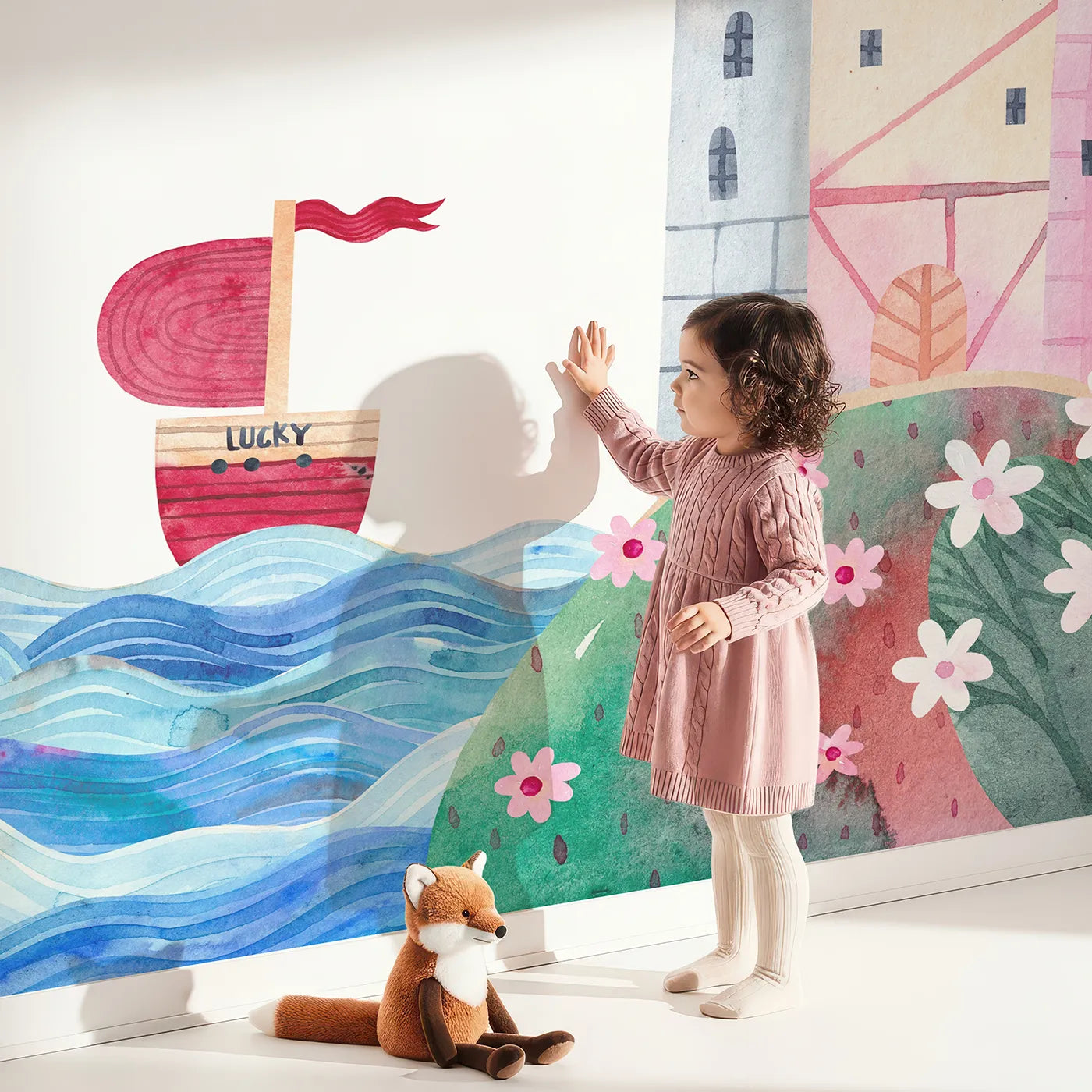 Child in front of Whimsy Tots Lucky Ship Castle Wall Mural with castle, ship, sea, rainbow, watercolor, fantasy, pink, fairytale in design.