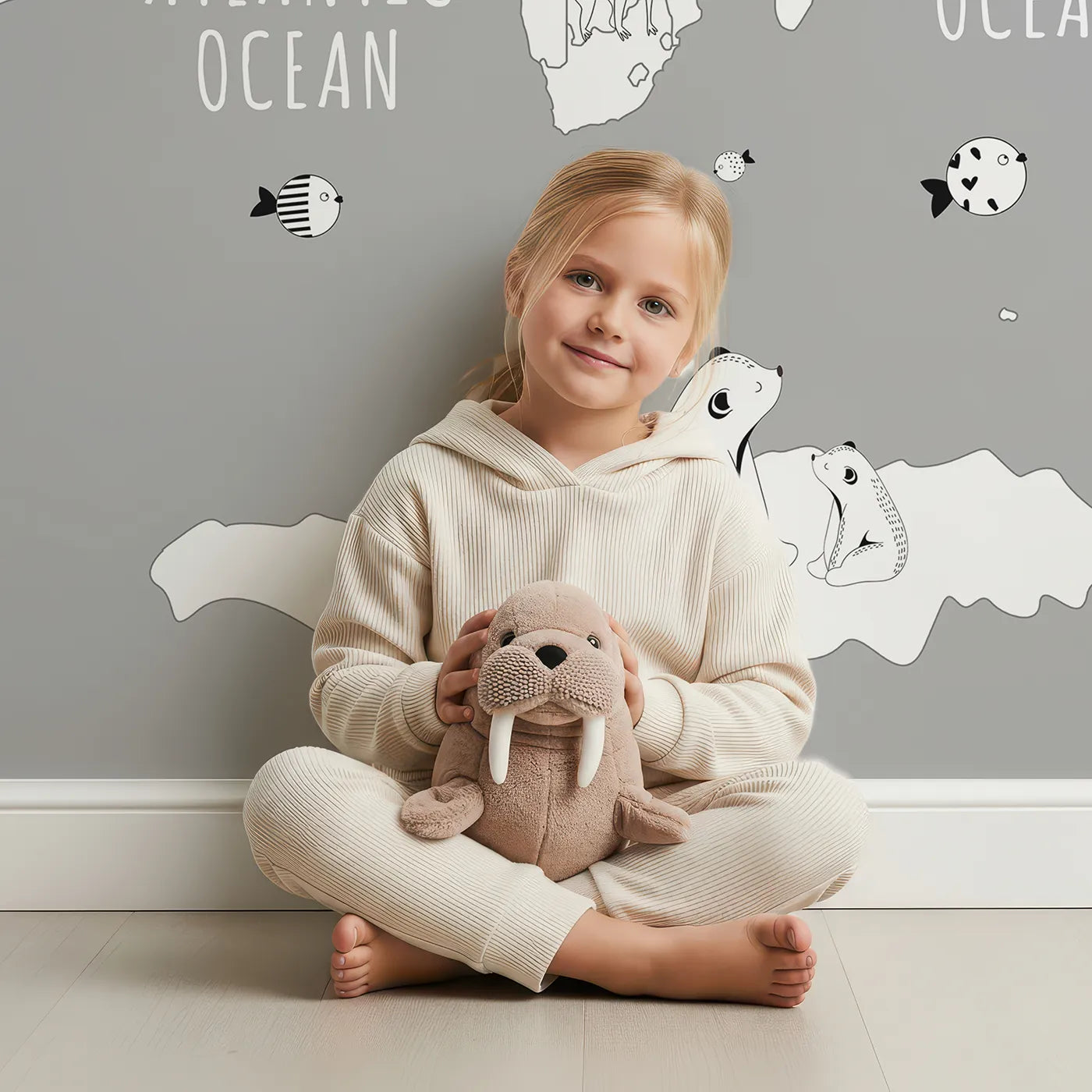 Child in front of Whimsy Tots Monochrome Animal World Map Wall Mural in Gray with map, world, animal, monochrome, gray, modern, educational, safari in design.