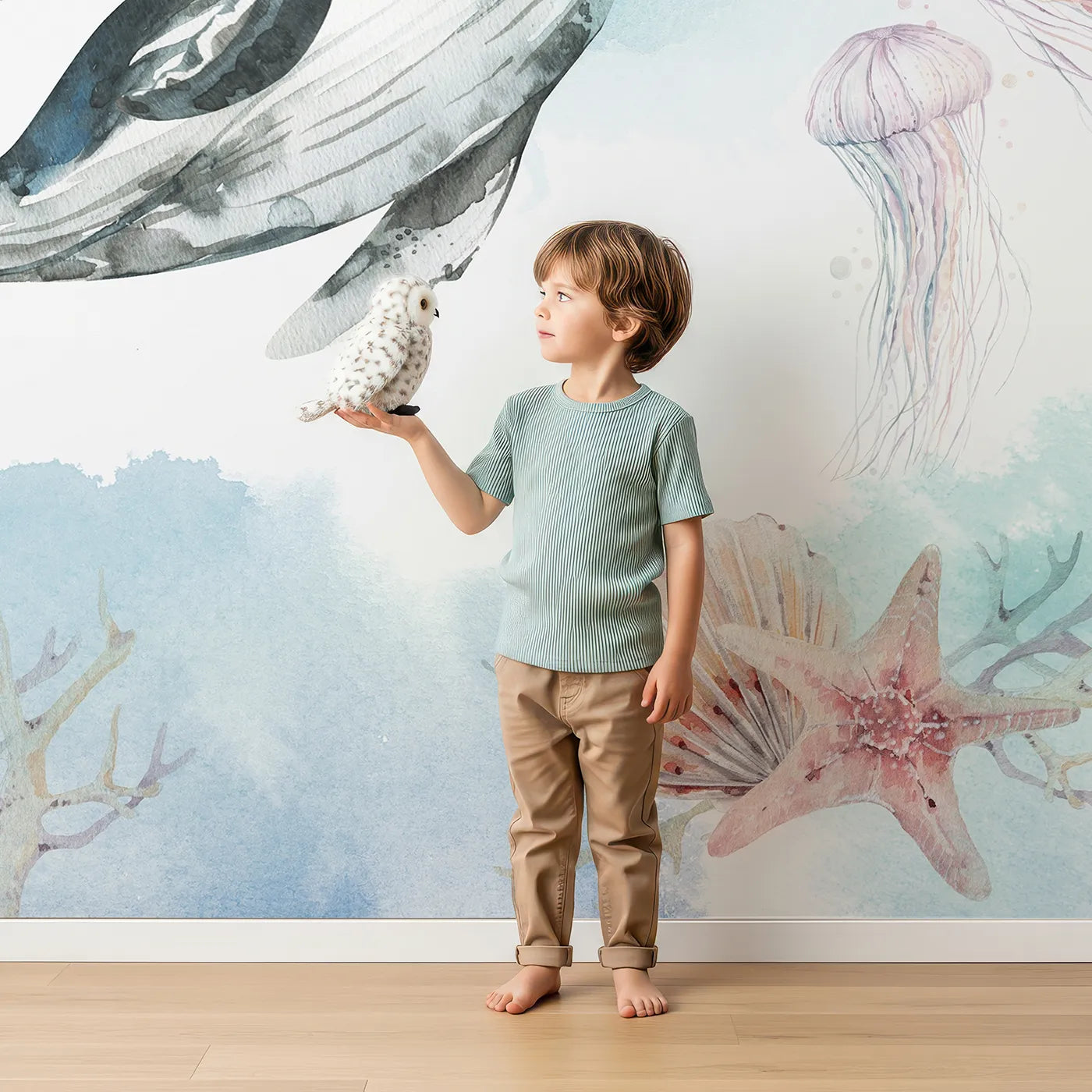 Child in front of Whimsy Tots Watercolor Whale Family Wall Mural with whale, sea, ocean, abstract, watercolor, blue, jellyfish, ethereal in design.