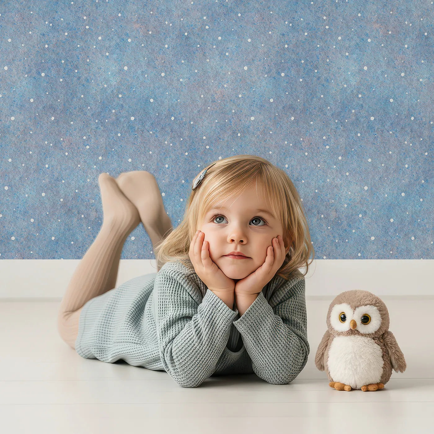 Lovely child standing in front of Whimsy Tots First Snowfall Wallpaper in Blue with snow, winter, blue, abstract, texture in design.