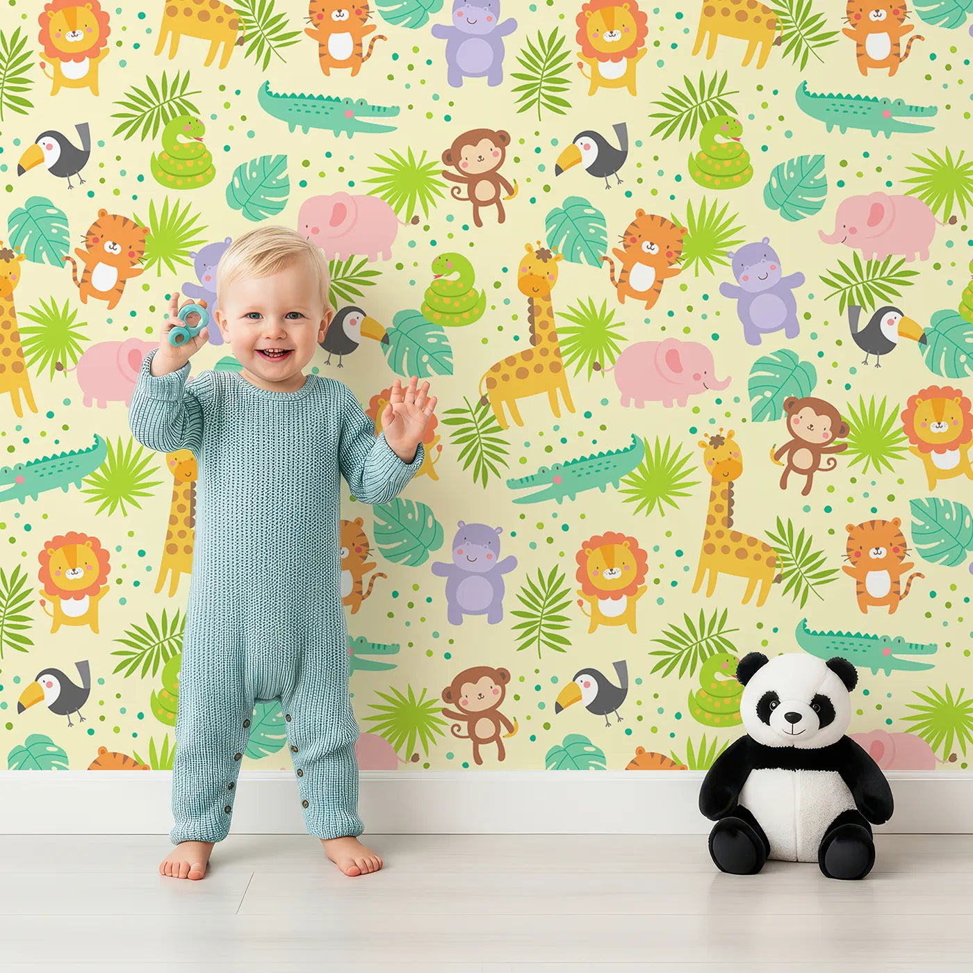 Lovely child standing in front of Whimsy Tots Happy Jungle Friends Wallpaper with jungle, safari, animal, lion, giraffe, elephant in design.