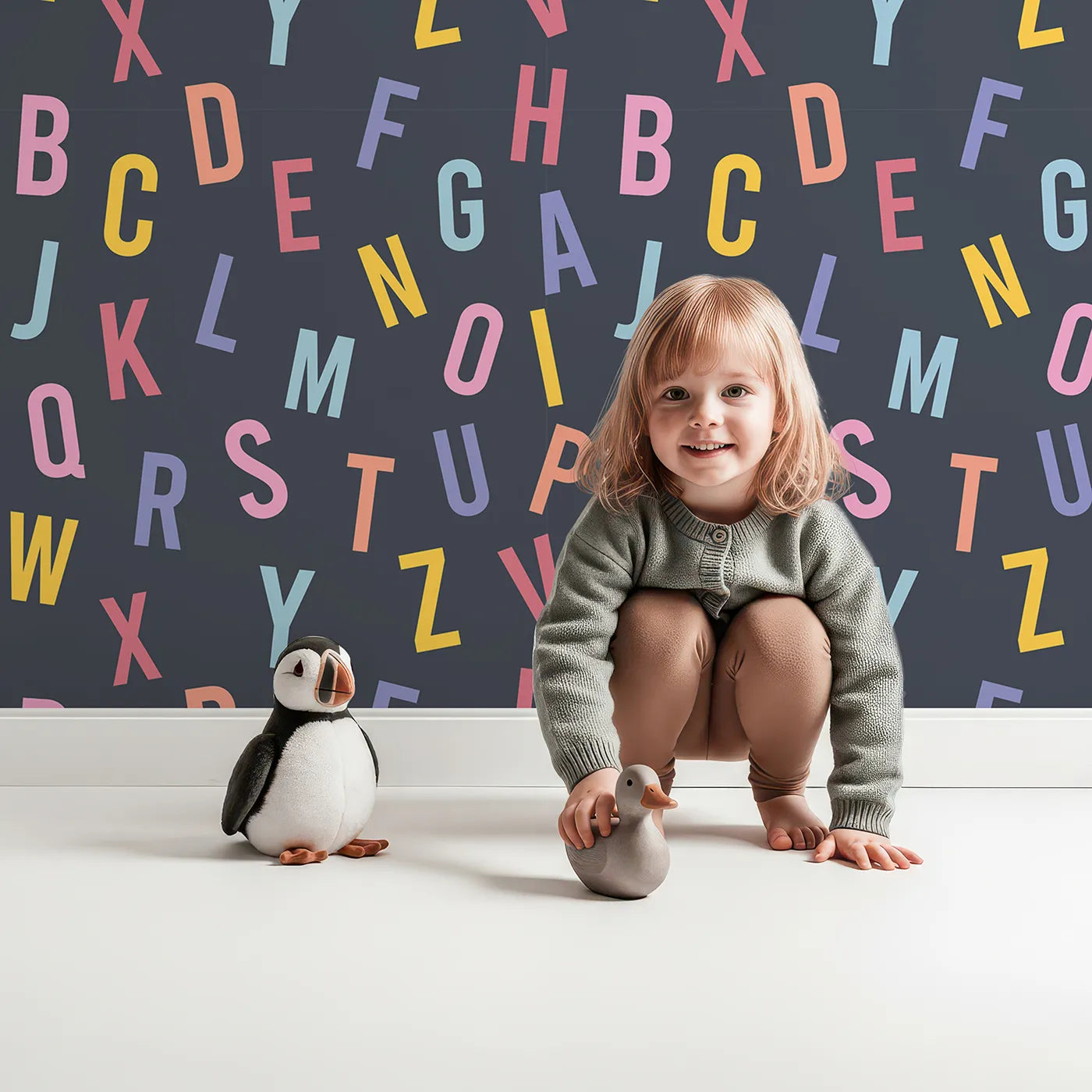 Lovely child standing in front of Whimsy Tots Colorful Alphabet Scatter Wallpaper with alphabet, letter, learning, typography, colorful in design.