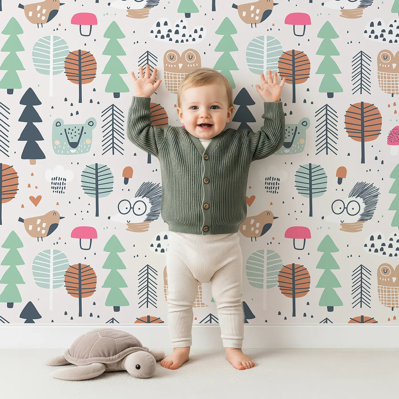 Lovely child standing in front of Whimsy Tots Scandinavian Woodland Friends Wallpaper with woodland, forest, bear, owl, hedgehog in design.