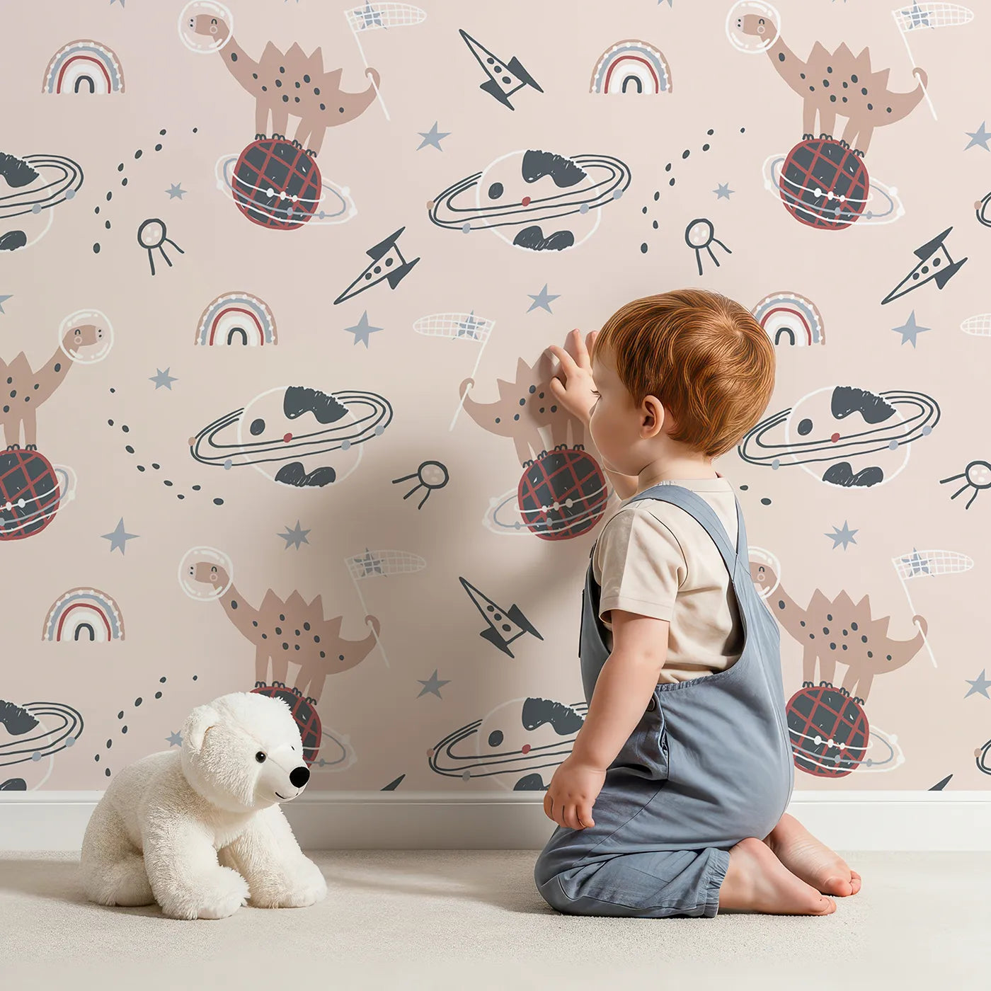 Lovely child standing in front of Whimsy Tots Dino Planet Explorer Wallpaper with dinosaur, space, planet, rocket, rainbow in design.