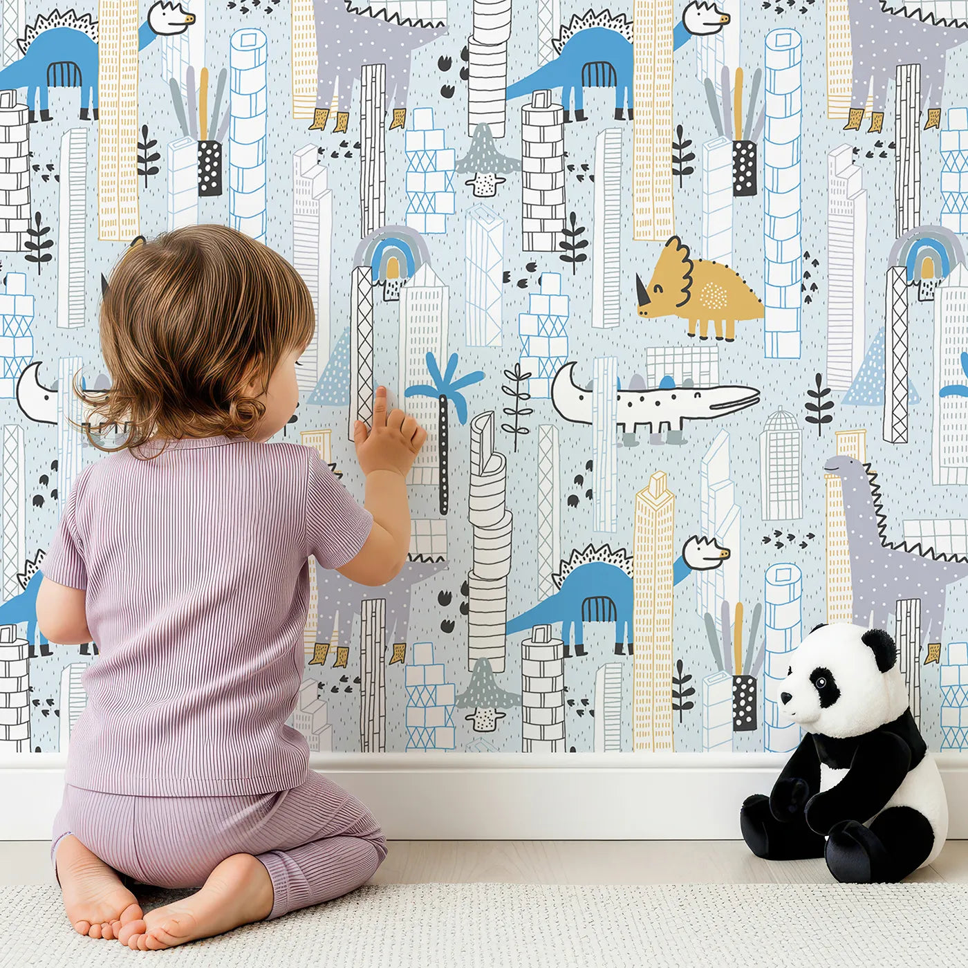 Lovely child standing in front of Whimsy Tots Dino City Adventure Wallpaper with dinosaur, city, building, modern, crocodile in design.