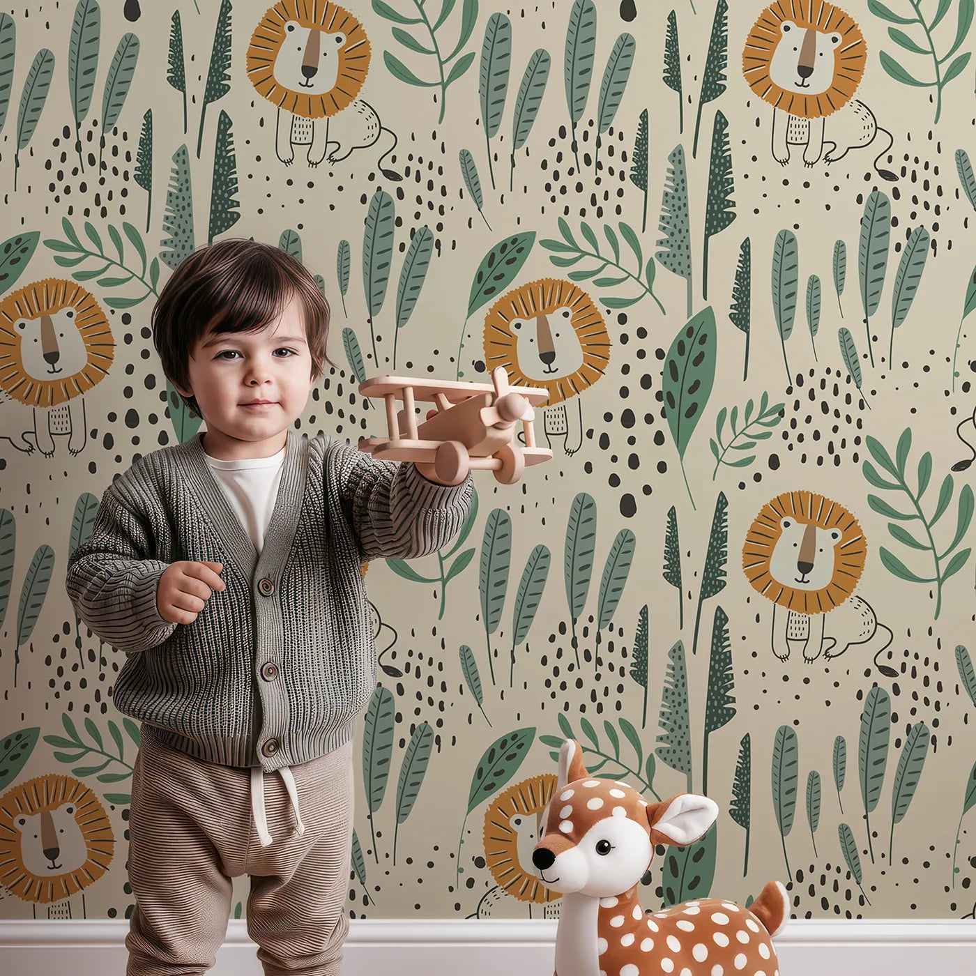 Lovely child standing in front of Whimsy Tots Jungle Lion Hideaway Wallpaper with lion, jungle, leaf, safari, modern in design.