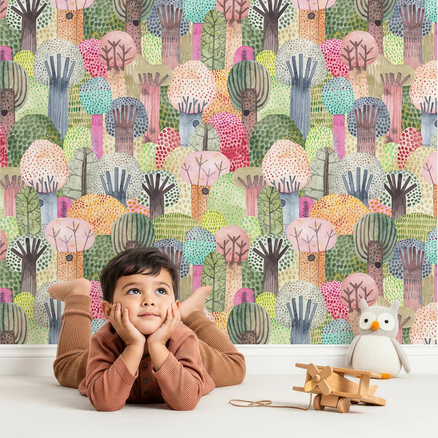 Lovely child standing in front of Whimsy Tots Vibrant Watercolor Forest Wallpaper with forest, tree, watercolor, abstract, colorful in design.