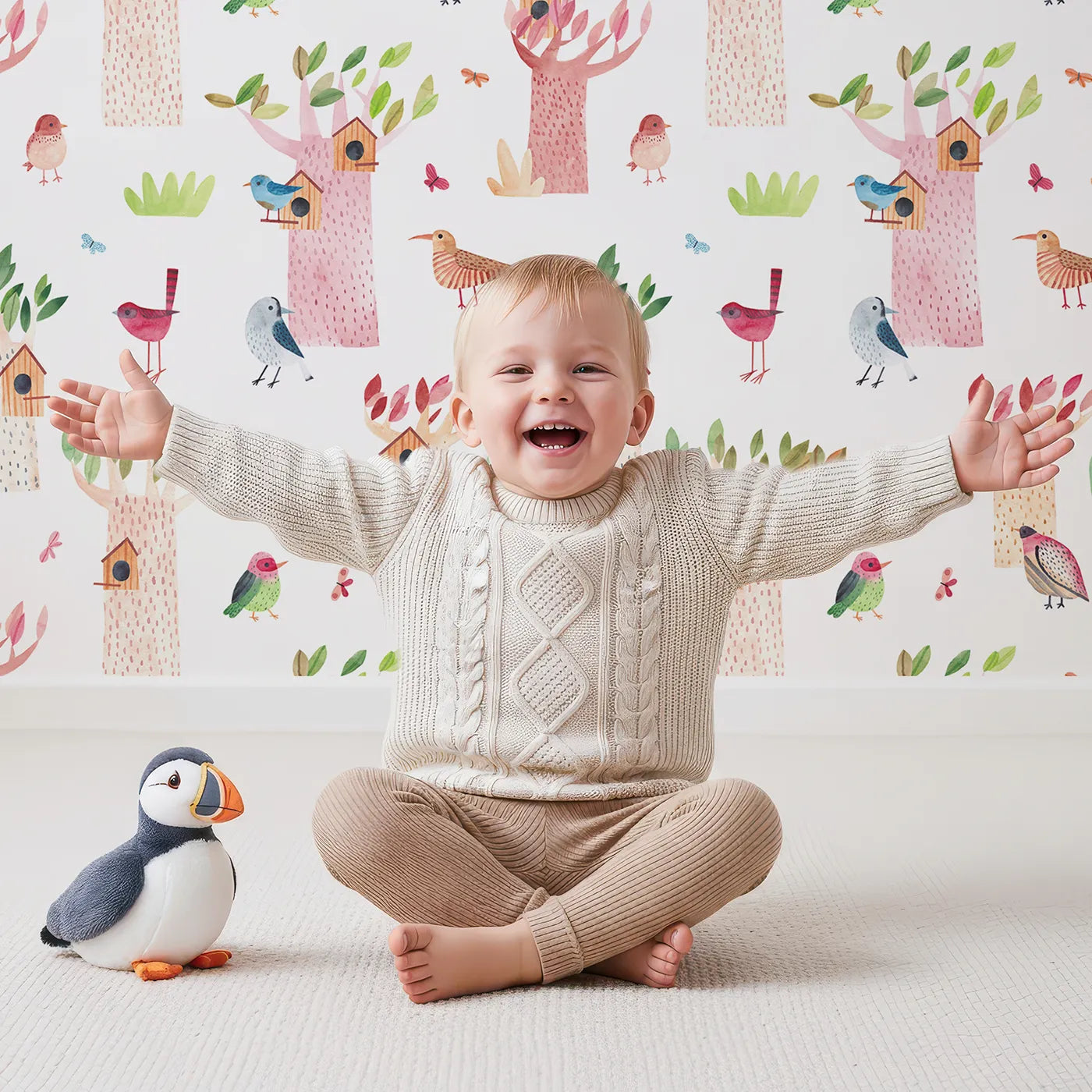 Lovely child standing in front of Whimsy Tots Watercolor Bird Sanctuary Wallpaper with bird, tree, birdhouse, watercolor, butterfly in design.