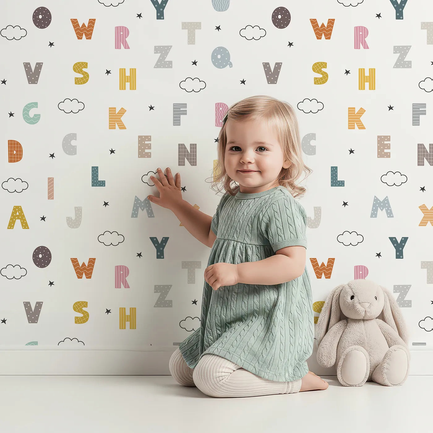 Lovely child standing in front of Whimsy Tots Starry Alphabet Clouds Wallpaper with alphabet, letter, cloud, star, learning in design.