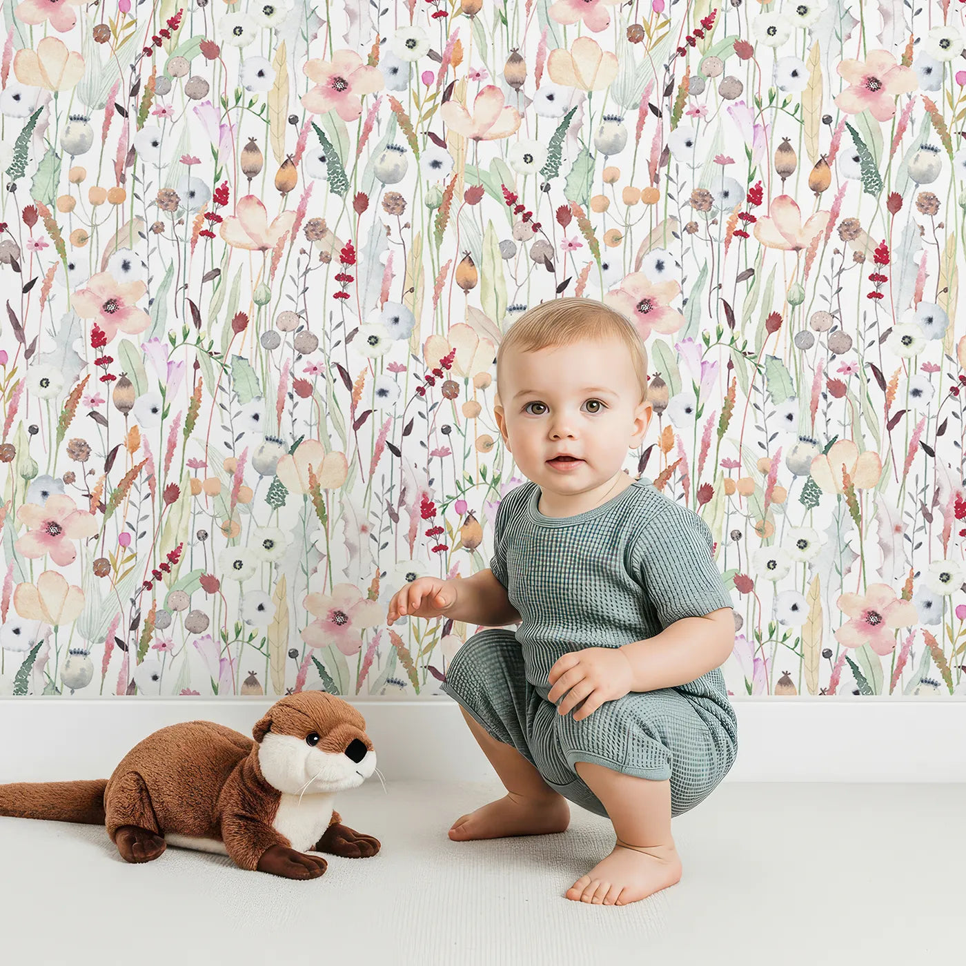 Lovely child standing in front of Whimsy Tots Neutral Wildflower Patch Wallpaper with flower, wildflower, watercolor, botanical, neutral in design.