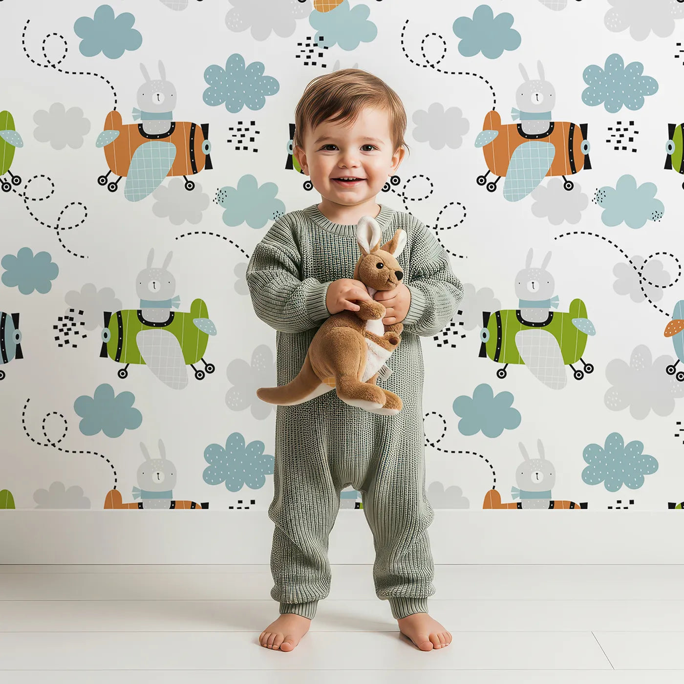 Lovely child standing in front of Whimsy Tots Bunny Pilot Sky Adventure Wallpaper with bunny, rabbit, plane, airplane, sky in design.