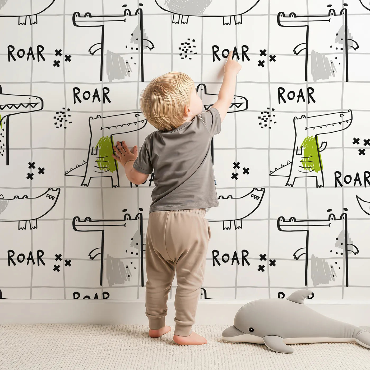 Lovely child standing in front of Whimsy Tots Crocodile Roar Doodle Wallpaper with crocodile, alligator, roar, doodle, grid in design.