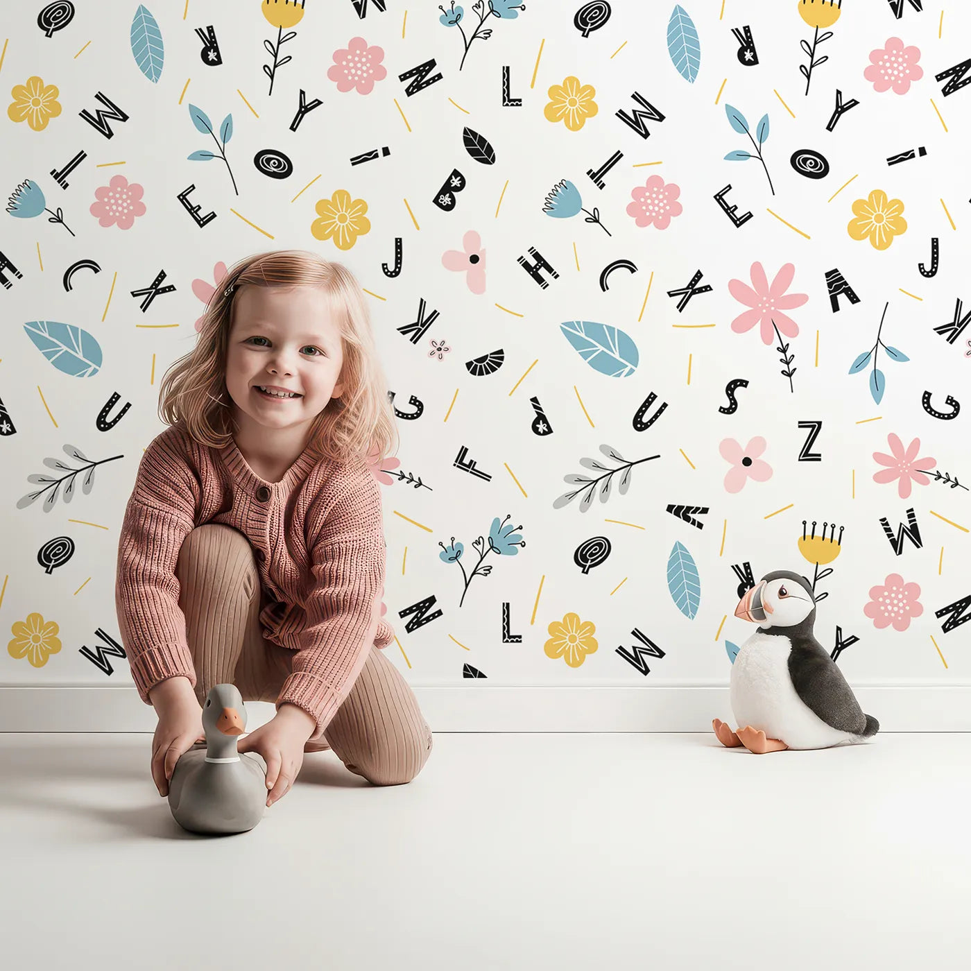 Lovely child standing in front of Whimsy Tots Floral Alphabet Garden Wallpaper with alphabet, flower, floral, letter, learning in design.