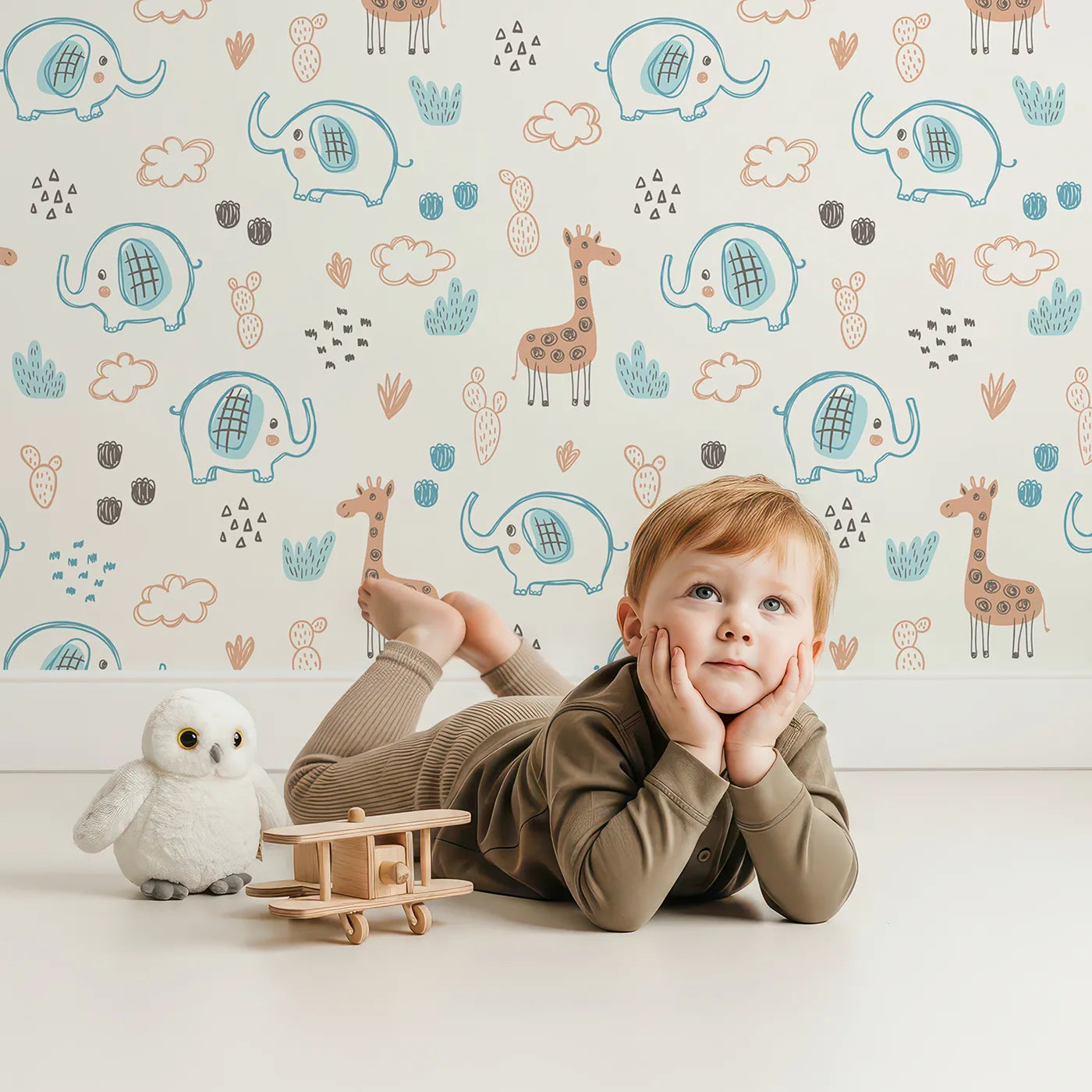 Lovely child standing in front of Whimsy Tots Safari Doodle Friends Wallpaper with elephant, giraffe, safari, doodle, cactus in design.