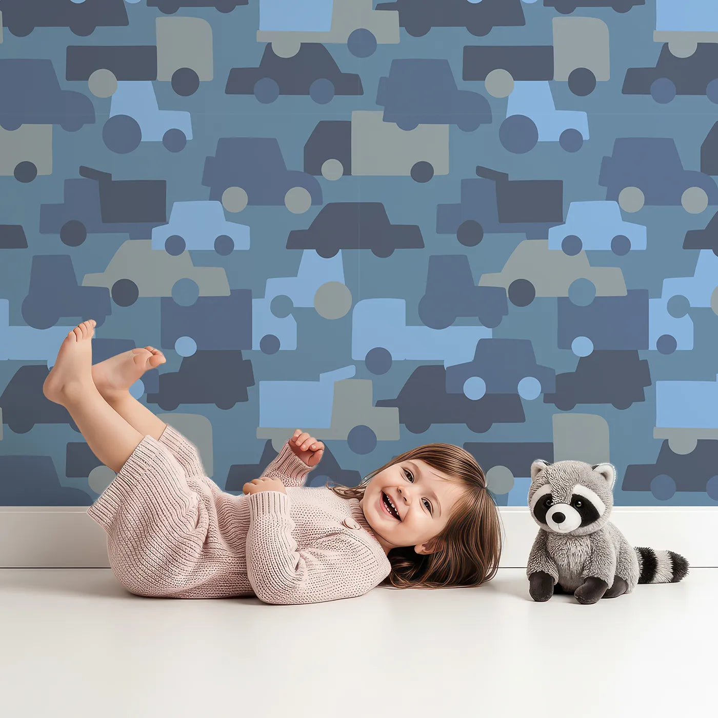 Lovely child standing in front of Whimsy Tots Blue Vehicle Camouflage Wallpaper with car, truck, camouflage, silhouette, blue in design.