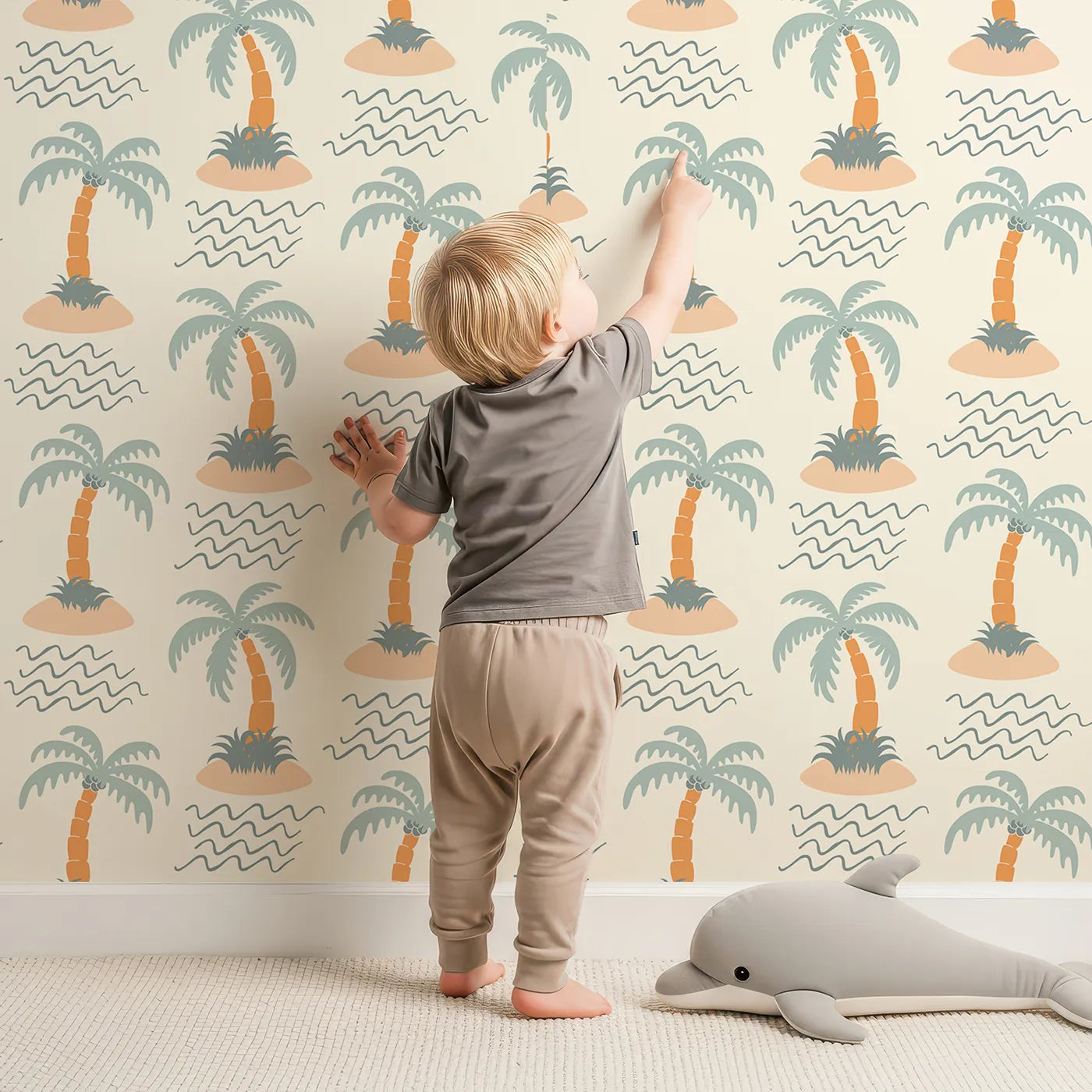 Lovely child standing in front of Whimsy Tots Tropical Island Getaway Wallpaper with palm tree, island, beach, tropical, minimalist in design.