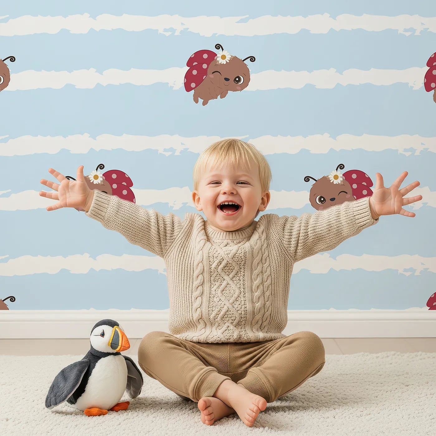 Lovely child standing in front of Whimsy Tots Winkie the Ladybug Wallpaper in Blue with ladybug, stripe, flower, bug in design.