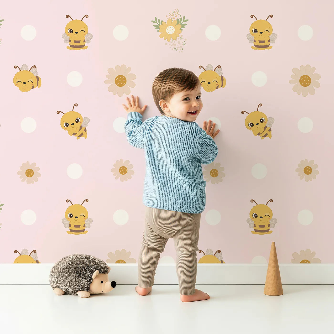 Lovely child standing in front of Whimsy Tots Buzzberry Bee Parade Wallpaper in Pink with bee, flower, daisy, dot in design.