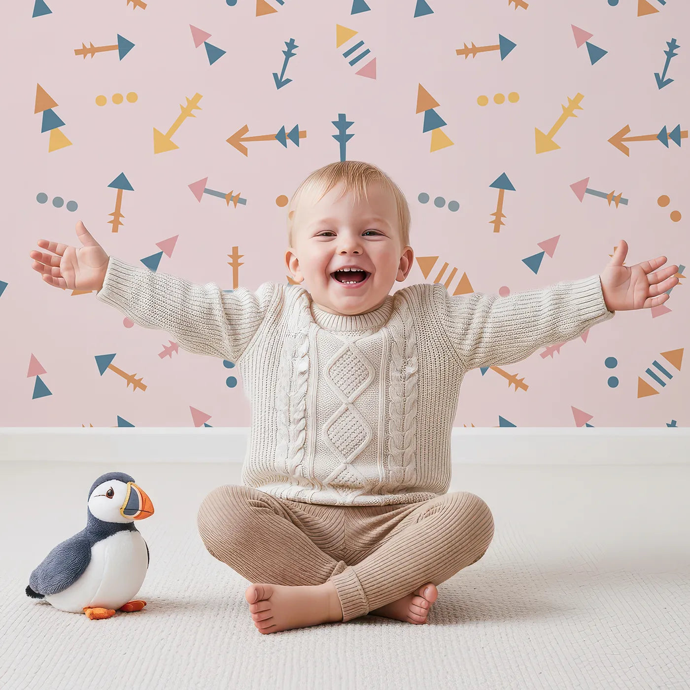Lovely child standing in front of Whimsy Tots Boho Arrows Wallpaper in Pink with arrow, triangle, dot in design.