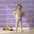 Lovely child standing in front of Whimsy Tots Tribal Sky Dance Wallpaper in Purple with arrow, feather, star, stripe in design. Lovely child standing in front of Whimsy Tots Tribal Sky Dance Wallpaper in Purple with arrow, feather, star, stripe in design.