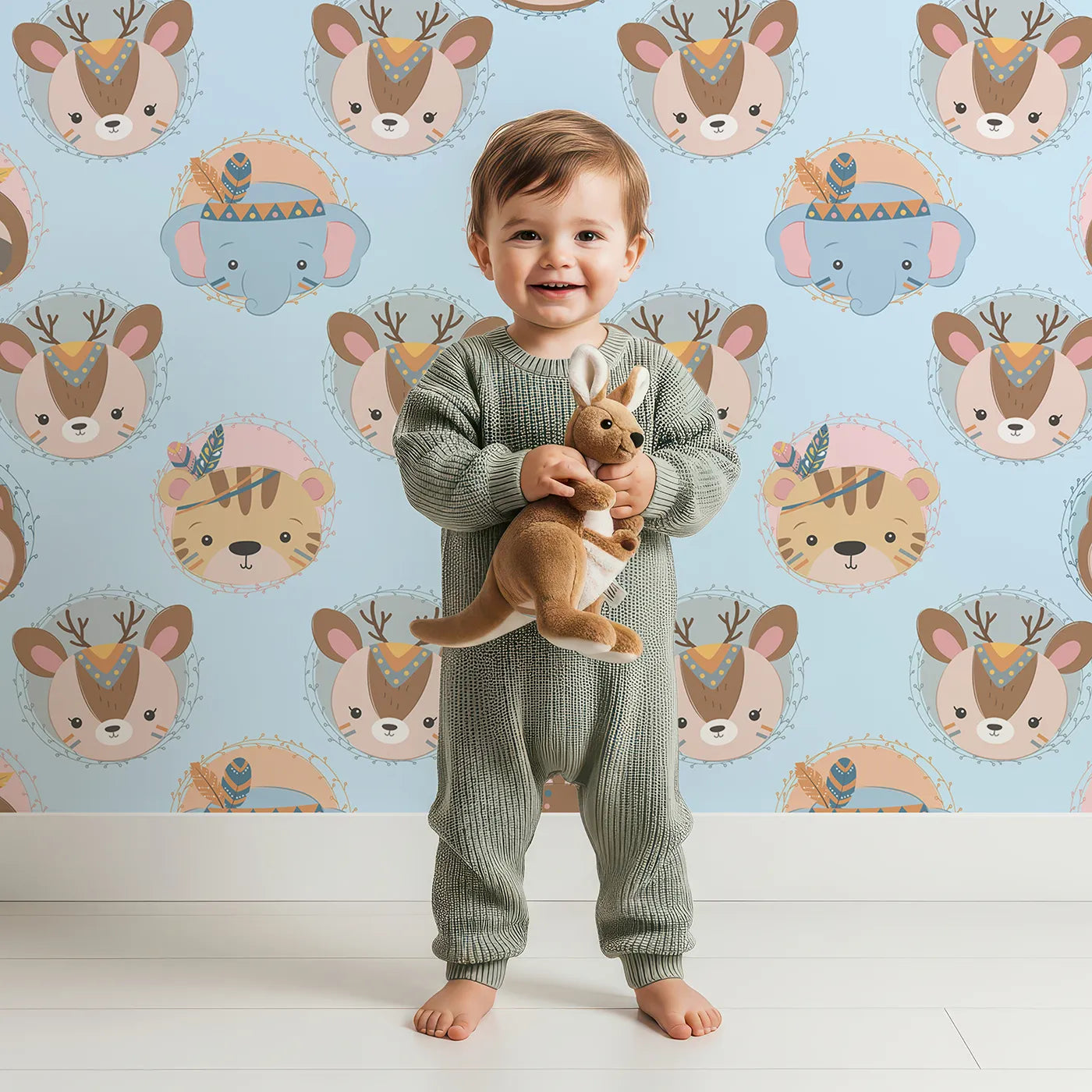 Lovely child standing in front of Whimsy Tots Woodland Royalty Parade Wallpaper in Blue with bear, deer, elephant, tiger, feather, wreath, crown in design.