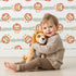 Lovely child standing in front of Whimsy Tots Striped Safari Cubs Wallpaper in Green with lion, stripe, paw in design. Lovely child standing in front of Whimsy Tots Striped Safari Cubs Wallpaper in Green with lion, stripe, paw in design.