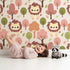 Lovely child standing in front of Whimsy Tots Autumn Safari Stroll Wallpaper in Beige with lion, tree, leaf in design. Lovely child standing in front of Whimsy Tots Autumn Safari Stroll Wallpaper in Beige with lion, tree, leaf in design.