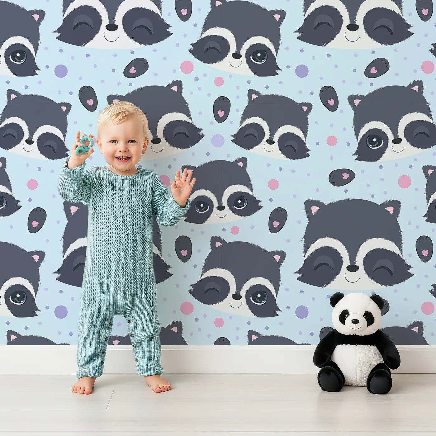 Lovely child standing in front of Whimsy Tots Winkie Raccoon Pals Wallpaper in Blue with raccoon, dot, paw in design.