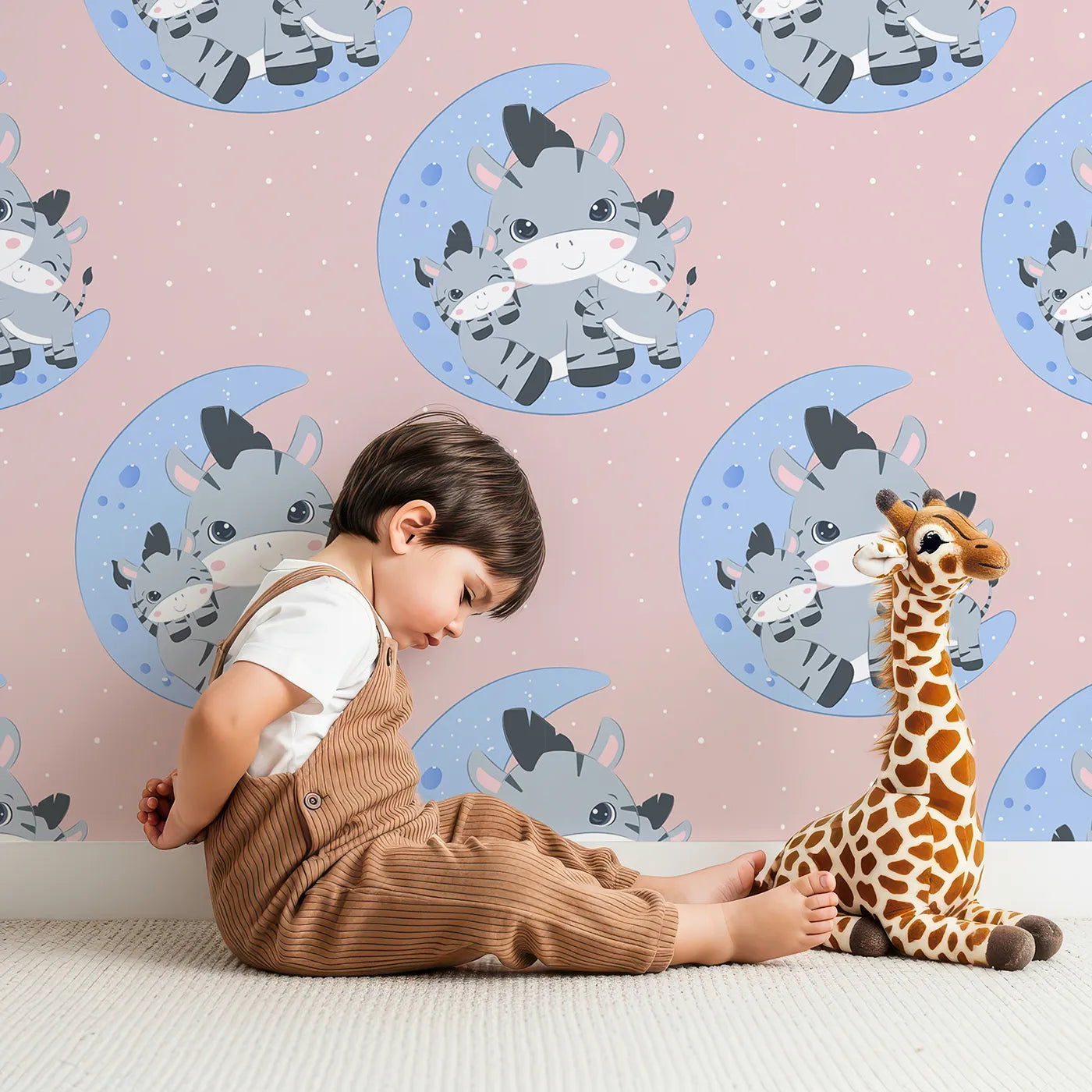 Lovely child standing in front of Whimsy Tots Moon Cuddles Zebra Wallpaper in Pink with zebra, moon, star in design.