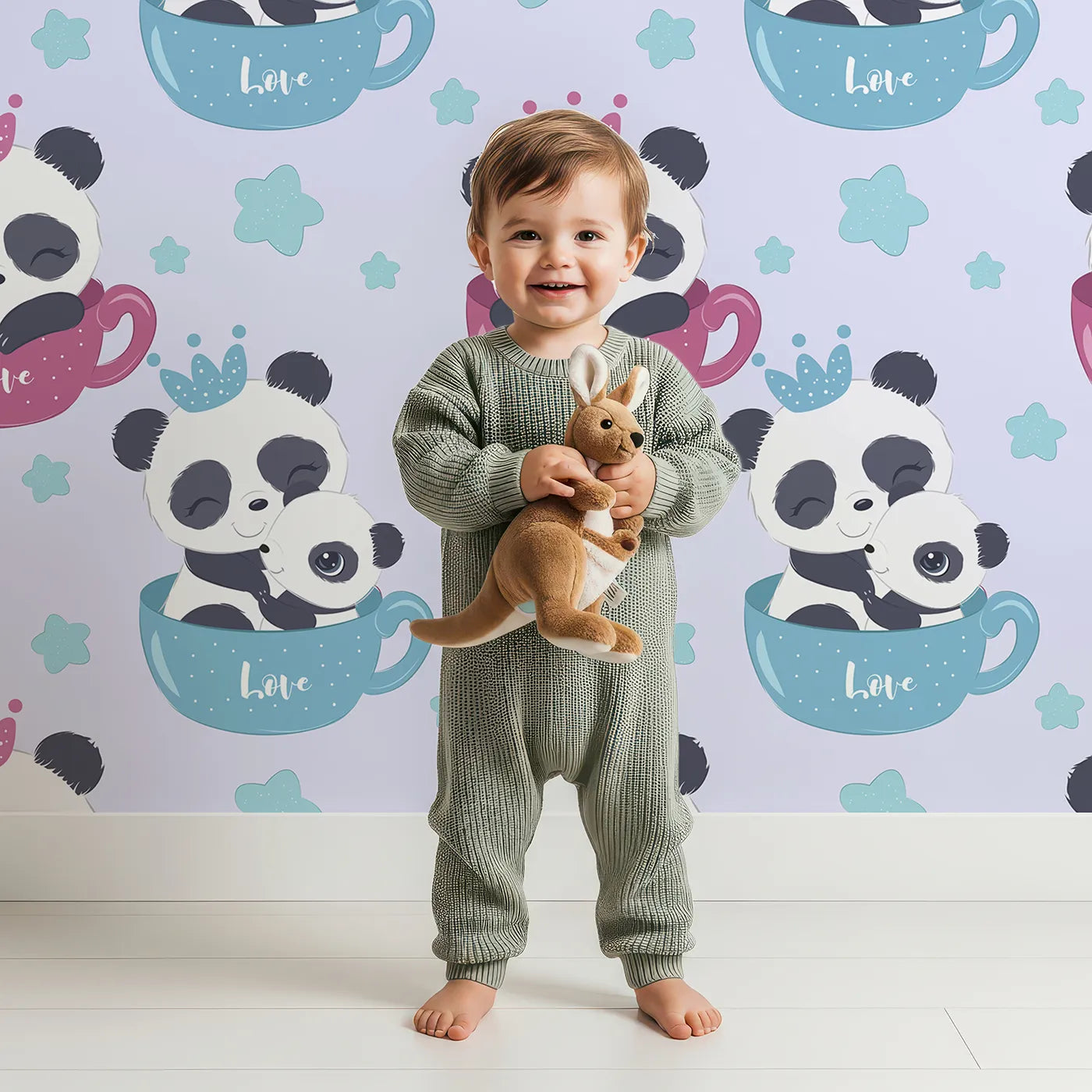 Lovely child standing in front of Whimsy Tots Cuddle Cup Panda Wallpaper in Lavender with panda, cup, star, crown in design.