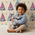 Lovely child standing in front of Whimsy Tots Tribal Camp Panda Wallpaper in Beige with panda, teepee, feather, arrow, dot in design. Lovely child standing in front of Whimsy Tots Tribal Camp Panda Wallpaper in Beige with panda, teepee, feather, arrow, dot in design.