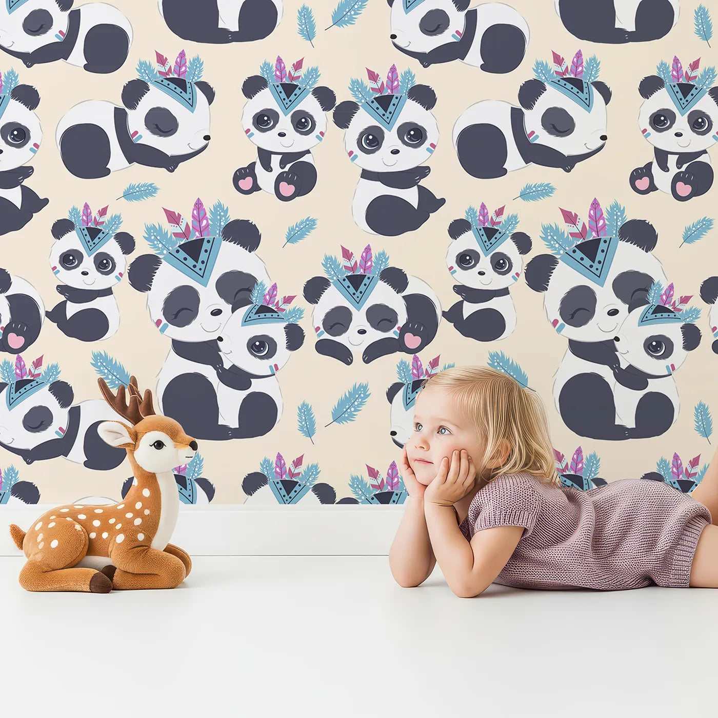Lovely child standing in front of Whimsy Tots Tribal Hug Panda Wallpaper in Beige with panda, feather, headband, hug, leaf in design.