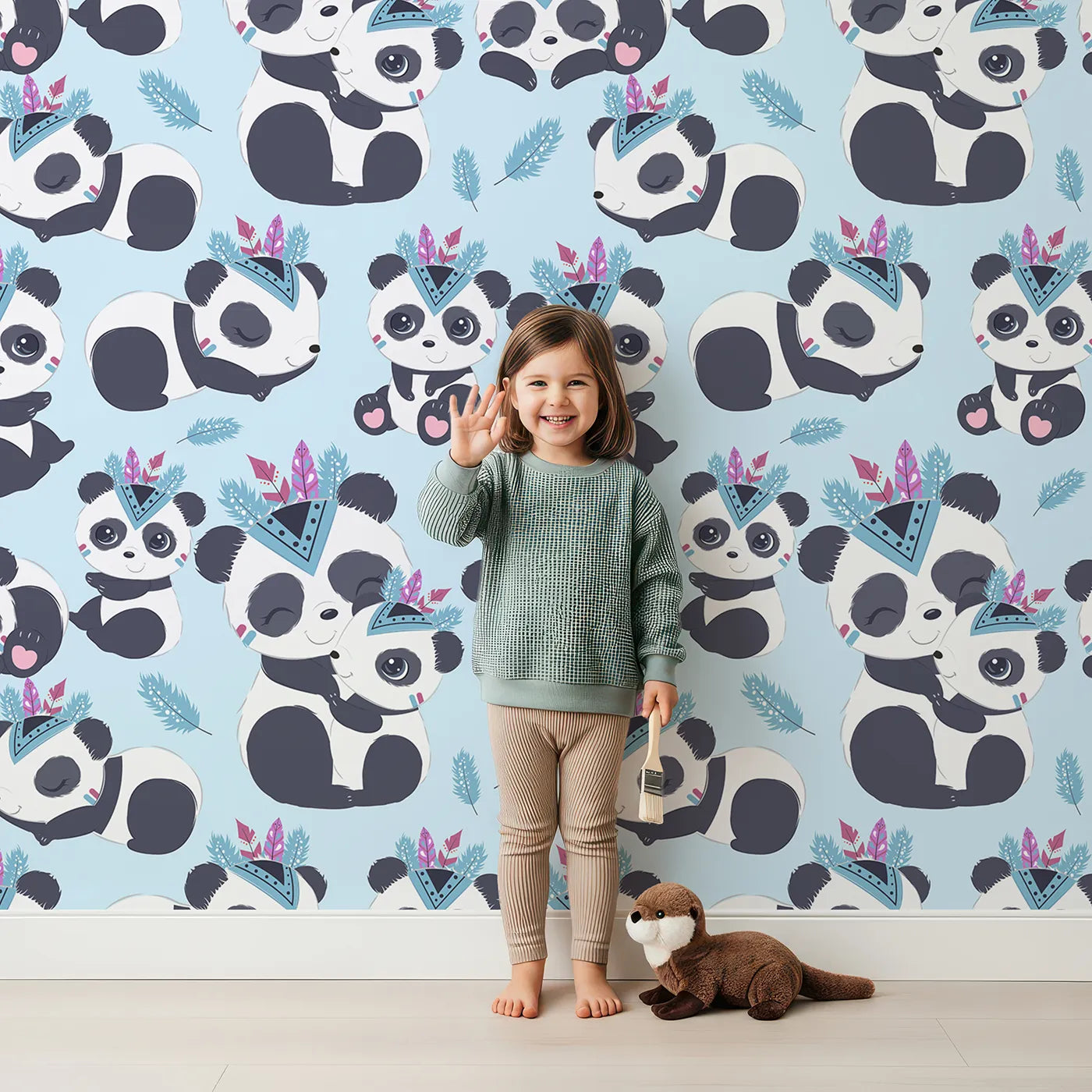 Lovely child standing in front of Whimsy Tots Tribal Hug Panda Wallpaper in Blue with panda, feather, headband, hug, leaf in design.