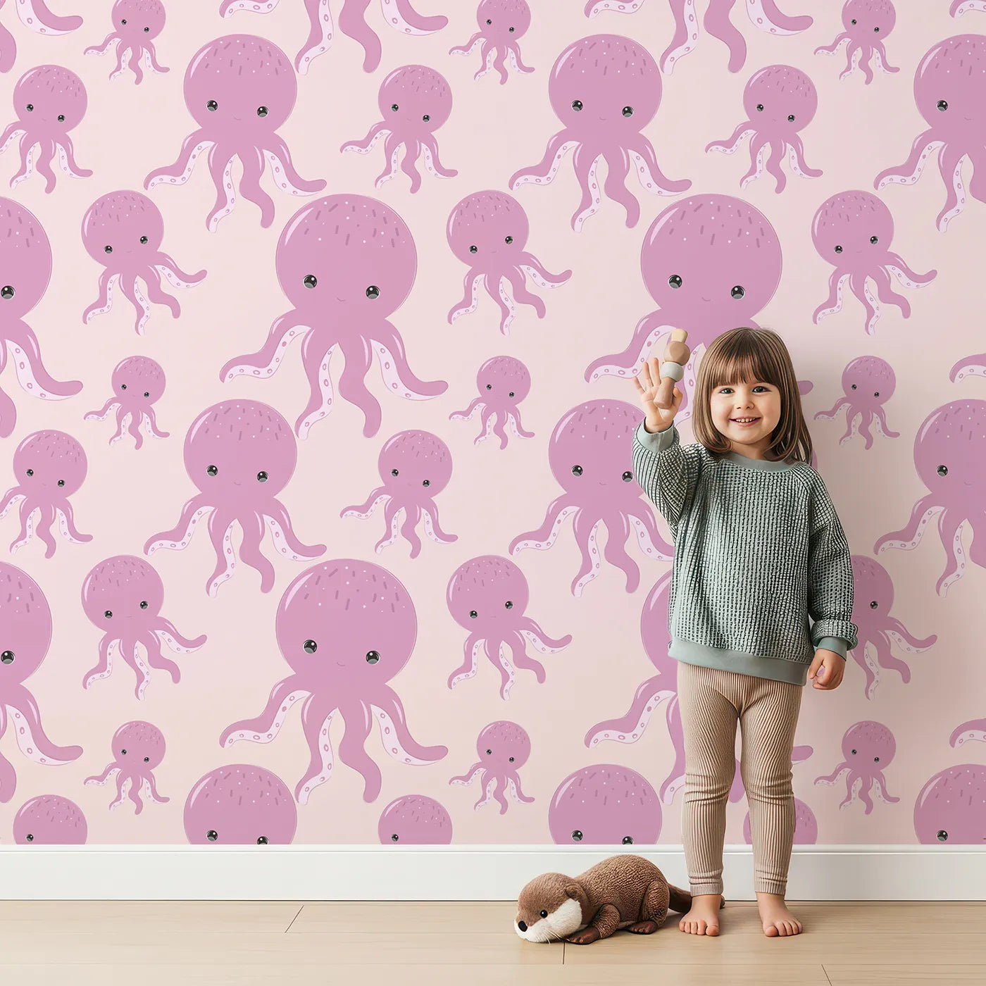 Lovely child standing in front of Whimsy Tots Ocean Bubbles Octopus Wallpaper in Blush Pink with octopus, tentacle, dot, sea in design.