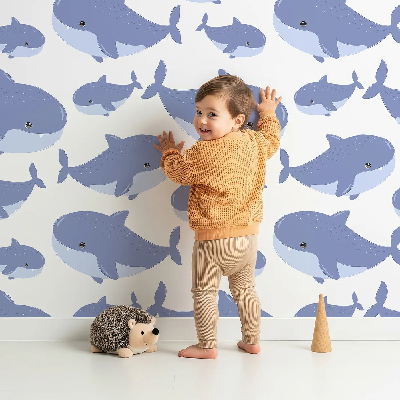 Lovely child standing in front of Whimsy Tots Whale Shark Wiggles Wallpaper in Blue with shark, whale shark, spot, sea in design.