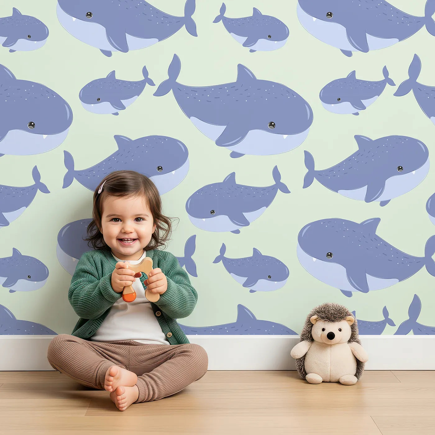 Lovely child standing in front of Whimsy Tots Whale Shark Wiggles Wallpaper in Mint Green with shark, whale shark, spot, sea in design.