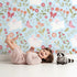 Lovely child standing in front of Whimsy Tots Meadow Hops Bunny Wallpaper in Blue with rabbit, butterfly, flower, leaf in design. Lovely child standing in front of Whimsy Tots Meadow Hops Bunny Wallpaper in Blue with rabbit, butterfly, flower, leaf in design.