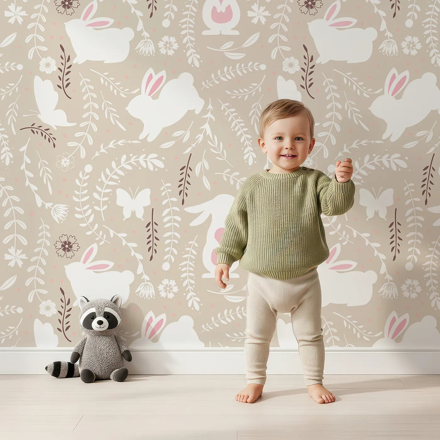 Lovely child standing in front of Whimsy Tots Bunny Hideaway Meadow Wallpaper in Sand with rabbit, butterfly, flower, vine in design.