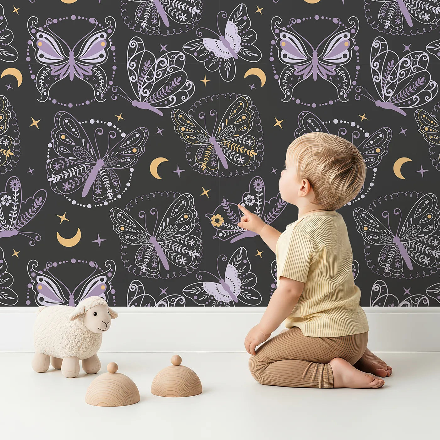 Lovely child standing in front of Whimsy Tots Starglow Garden Butterfly Wallpaper in Charcoal Gray with butterfly in design.