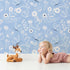 Lovely child standing in front of Whimsy Tots Floral Flutter Butterfly Wallpaper in Powder Blue with butterfly, flower, leaf in design. Lovely child standing in front of Whimsy Tots Floral Flutter Butterfly Wallpaper in Powder Blue with butterfly, flower, leaf in design.