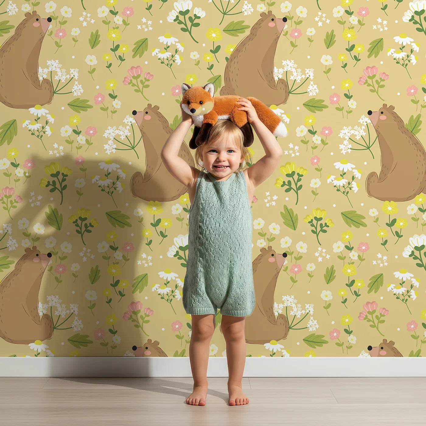 Lovely child standing in front of Whimsy Tots Blossom Bear Meadow Wallpaper in Honey Gold with bear, flower, leaf, blossom in design.