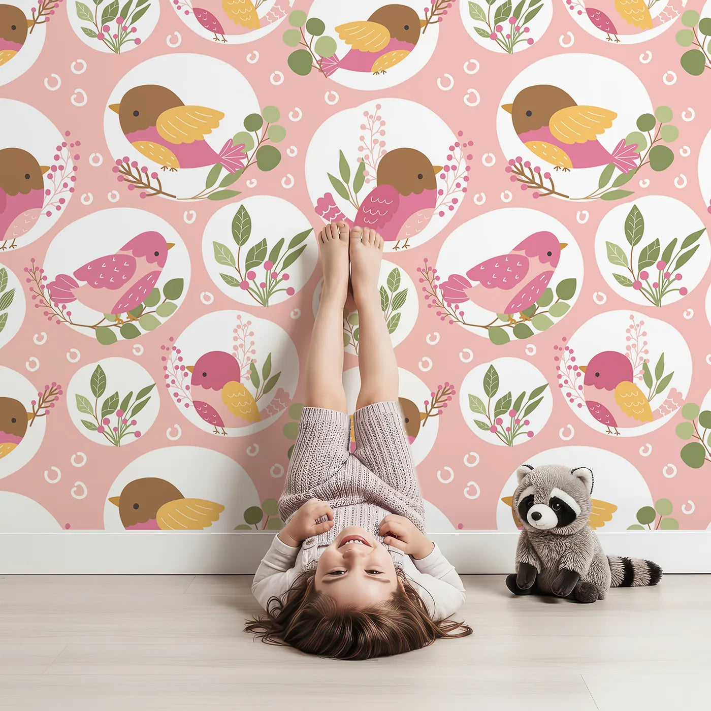 Lovely child standing in front of Whimsy Tots Garden Songbird Parade Wallpaper in Blush Pink with bird, branch, leaf, berry in design.