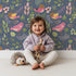 Lovely child standing in front of Whimsy Tots Bramble Songbird Garden Wallpaper in Navy Blue with bird, leaf, berry, flower, twig in design. Lovely child standing in front of Whimsy Tots Bramble Songbird Garden Wallpaper in Navy Blue with bird, leaf, berry, flower, twig in design.