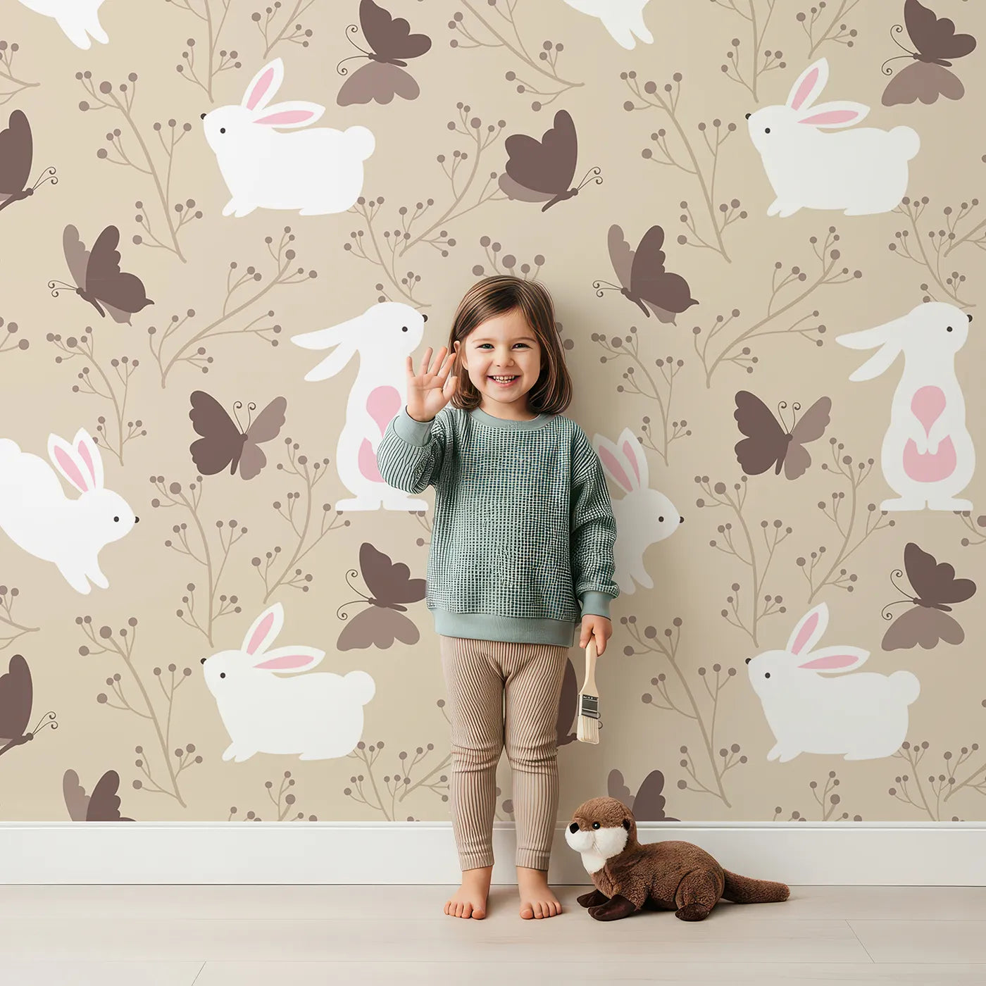Lovely child standing in front of Whimsy Tots Bunny and Butterfly Meadow Wallpaper in Beige with rabbit, butterfly, bunny, branch, leaf in design.