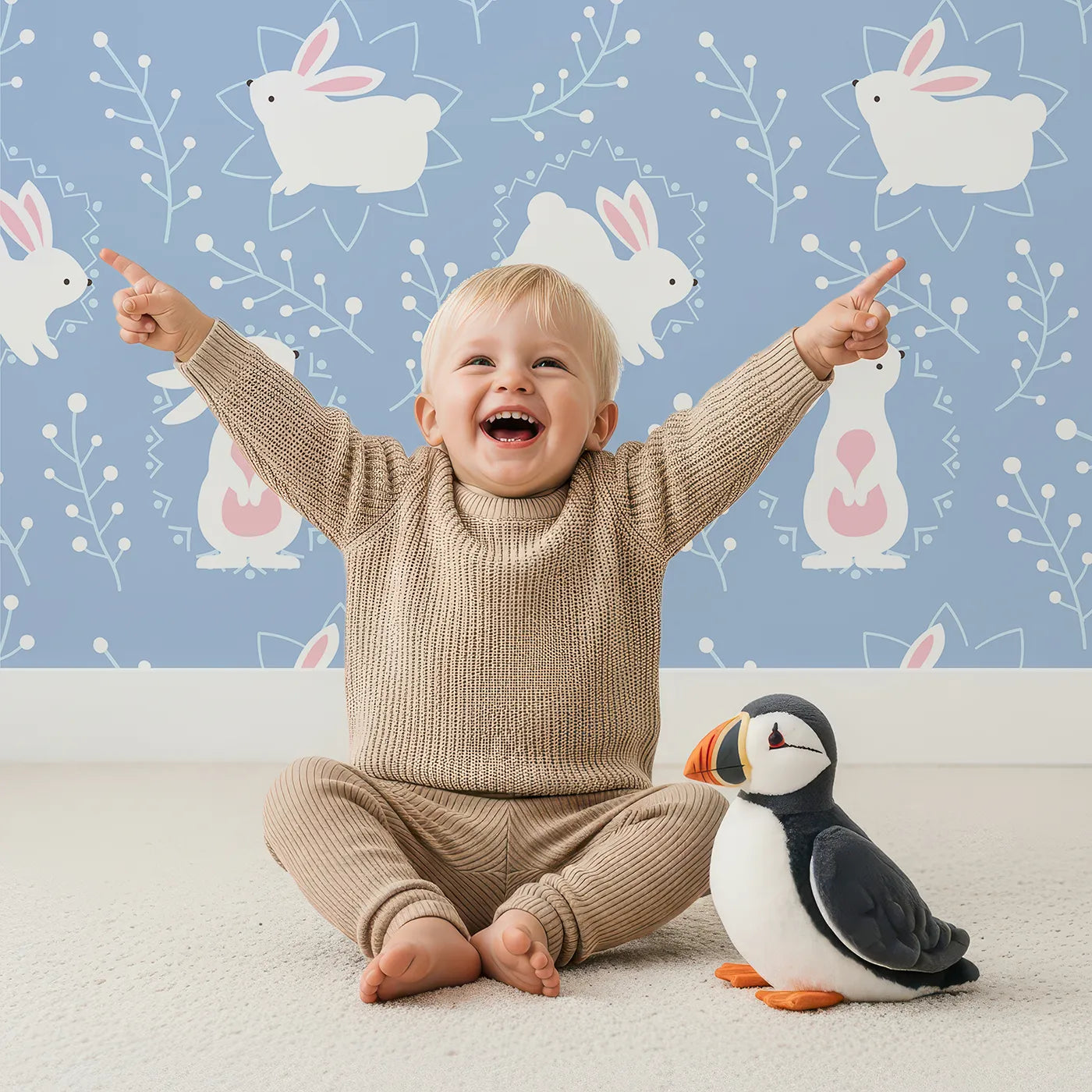 Lovely child standing in front of Whimsy Tots Tribal Bunny Sprigs Wallpaper in Sky Blue with rabbit, bunny, sprig, leaf, tribal motif in design.