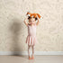 Lovely child standing in front of Whimsy Tots Desert Dino Parade Wallpaper in Sand with dinosaur, cactus, flower in design. Lovely child standing in front of Whimsy Tots Desert Dino Parade Wallpaper in Sand with dinosaur, cactus, flower in design.