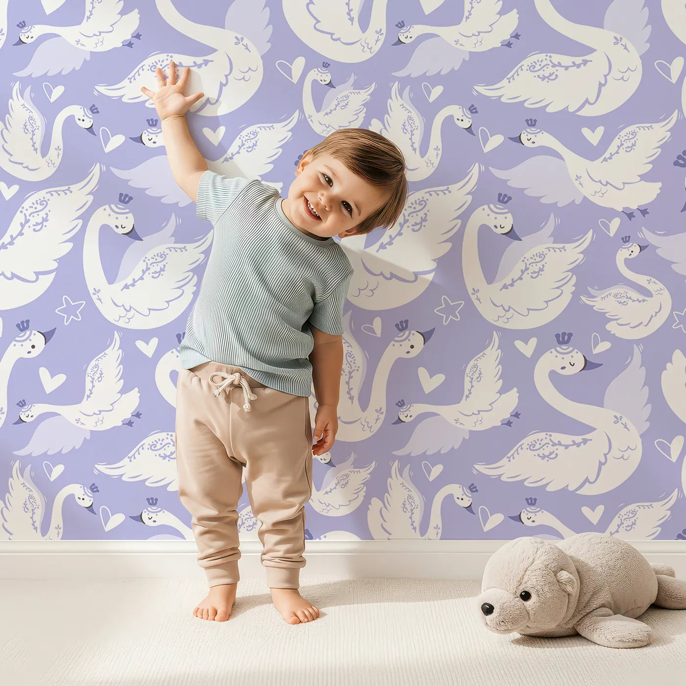 Lovely child standing in front of Whimsy Tots Swan Princess Waltz Wallpaper in Lavender with swan, crown, wing, heart, star in design.
